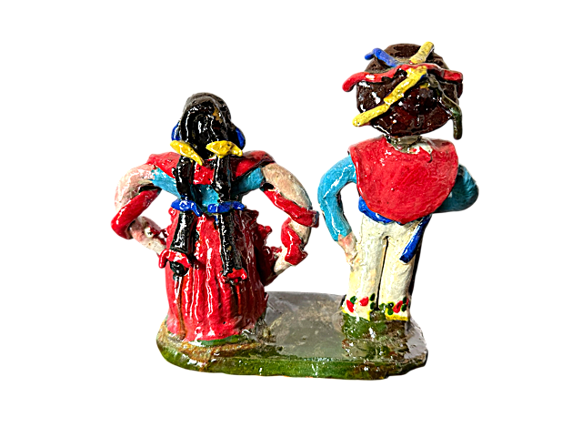Detalle trasero de pareja en barro vidriado rojo y azul; muestra la caída del gabán tradicional y la textura lisa y brillante característica de la alfarería de San José de Gracia.