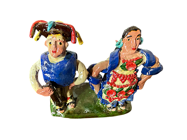 scultura de barro vidriado de Doña Luz; figuras de pueblos originarios con hombre en gabán azulvibrante y mujer con mandil blanco con flores, pieza auténtica de la colección Mansion Iturbe Artisans.