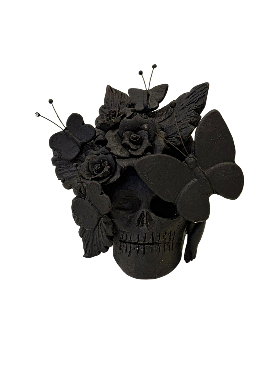 cráneo de barro en acabado negro con detalles de mariposas y flores en pastillaje, artesanía de Mansión Iturbe Artisans Collection.