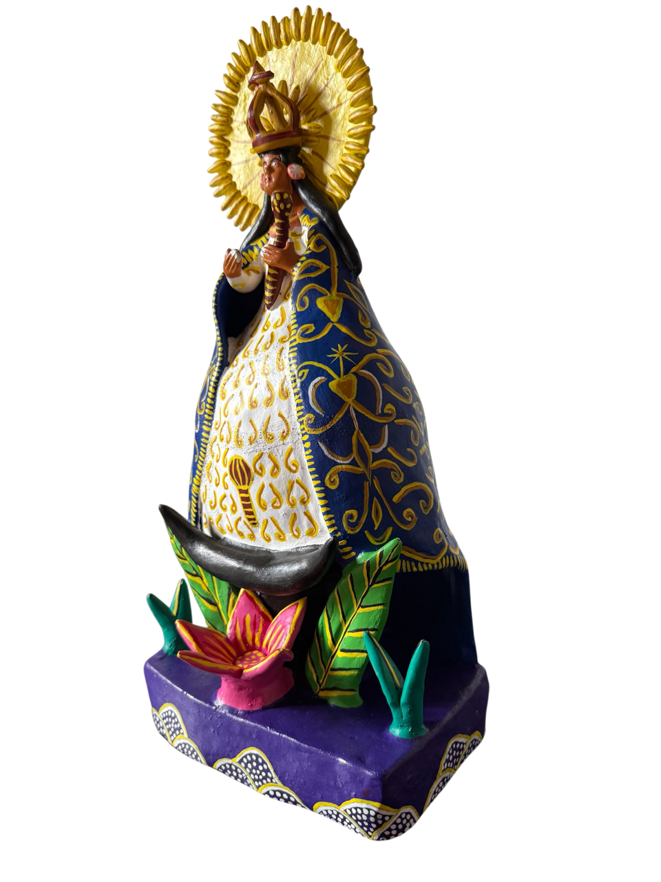 Vista lateral de escultura de la Virgen de la Salud de Pátzcuaro elaborada a mano en Ocumicho, Michoacán, mostrando texturas de barro policromado y diseño único de arte mexicano.