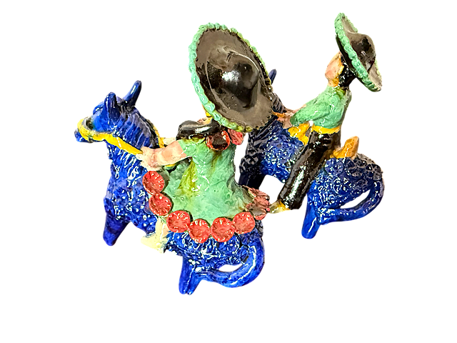 Vista trasera de la pareja de charros de barro azul, mostrando el intrincado calado de flores en el vestido de la dama y la textura vidriada, resaltando el comercio justo.