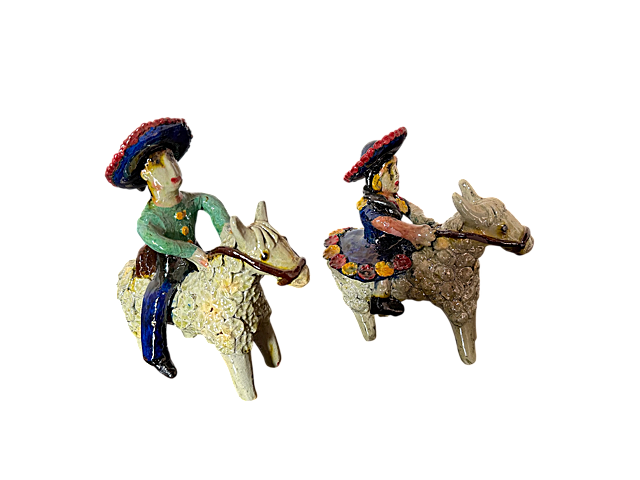 Vista en ángulo de tres cuartos de una pareja de charros a caballo de barro vidriado blanco, obra de Doña Luz, ideal para un ambiente Warm Minimalist.