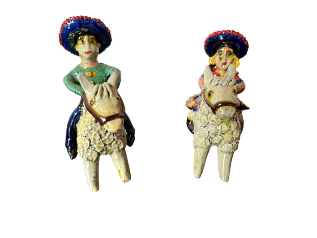 Vista de frente de la pareja de charros a caballo en barro vidriado blanco, obra de Doña Luz, ideal para regalos sostenibles con impacto.