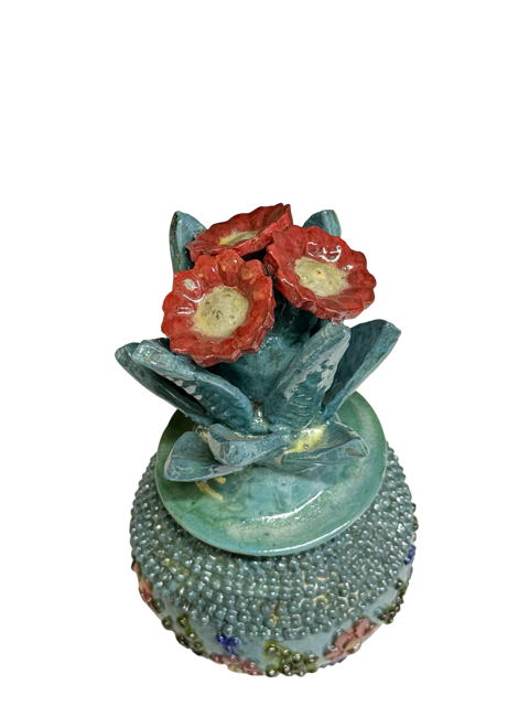 Vista superior (cenital) del penacho de la piña de barro, mostrando las flores detalladas en rosa oscuro casi rojo y la técnica artesanal de pellizco, Mansion Iturbe Artisans Collection.