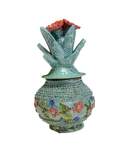 Vista frontal de piña de barro vidriado turquesa con cenefa color hueso y flores rosa oscuro, artesanía hecha a mano por mujer artesana de San José de Gracia, Michoacán