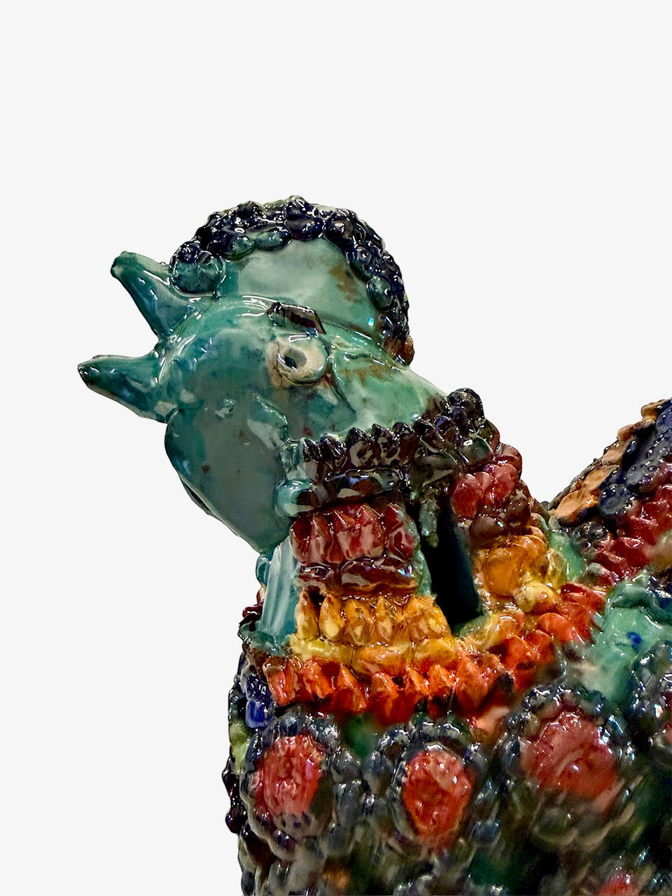 Acercamiento a la cabeza y cresta de gallo artesanal en barro vidriado, mostrando la textura y brillo del esmalte de alta temperatura.