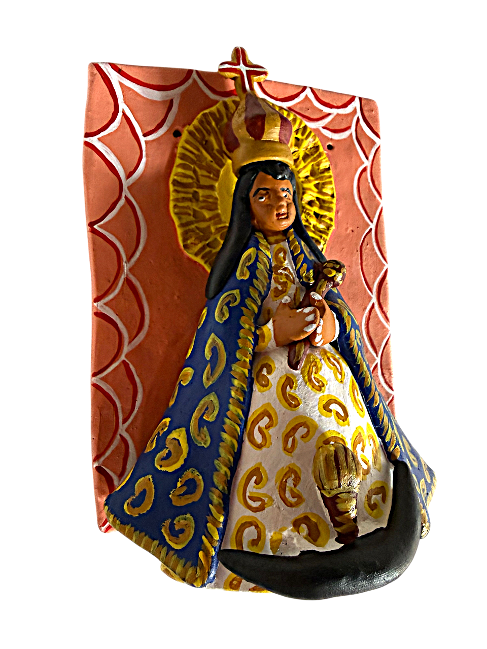 Detalle macro del relieve de la Virgen en el retablo rosa. Enfoque nítido en el modelado manual del barro y en los colores vivos (amarillos, azules, rojos) de los diablitos y la decoración que la rodea. Muestra de comercio justo de Michoacán.