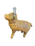 Perfil completo del toro de barro vidriado amarillo de Doña Luz. La foto resalta la densa textura de pastillaje manual, mostrando cientos de pequeñas flores de barro que cubren el lomo y el costado de la pieza. Se observa el contraste con los cuernos blanco hueso y las sutiles imperfecciones naturales que autentifican su origen artesanal en Michoacán.