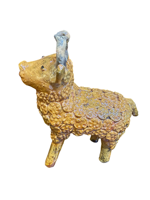 Perfil completo del toro de barro vidriado amarillo de Doña Luz. La foto resalta la densa textura de pastillaje manual, mostrando cientos de pequeñas flores de barro que cubren el lomo y el costado de la pieza. Se observa el contraste con los cuernos blanco hueso y las sutiles imperfecciones naturales que autentifican su origen artesanal en Michoacán.