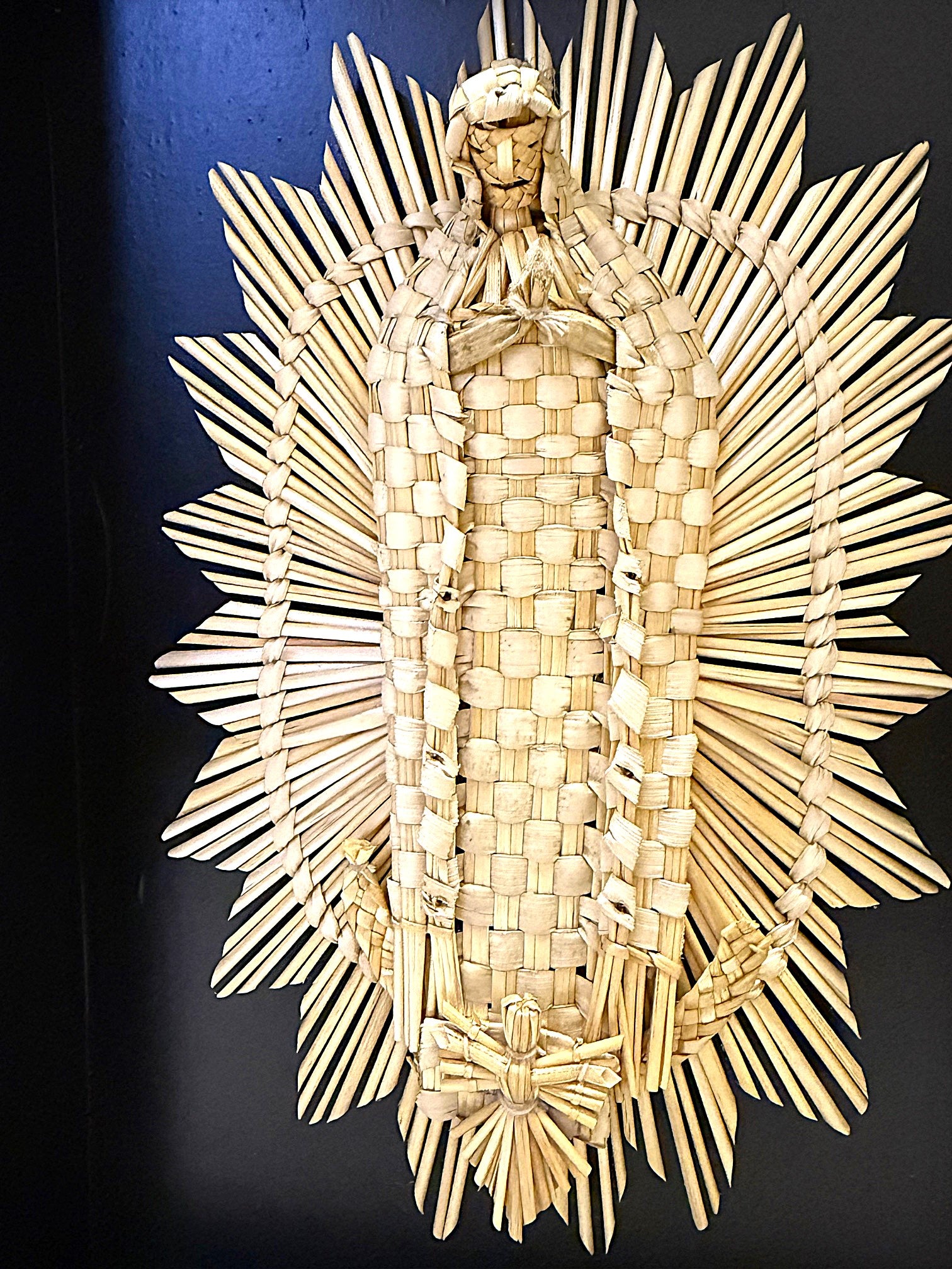 Virgen de Guadalupe de fibra vegetal panikua sobre base negra, artesanía de Michoacán en Mansión Iturbe Artisans Collection